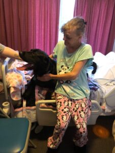 Woman on hospital bed with dog