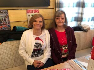 Two women looking at camera in Christmas jumpers