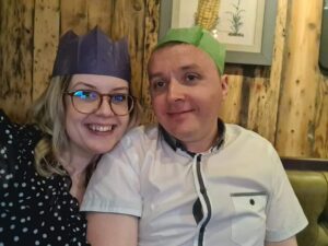 A couple looking at the camera with Christmas hats on