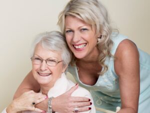 Mum and daughter embracing, smiling at camera