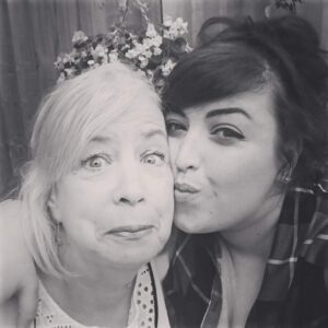 Black and white image of two women embracing and smiling at camera