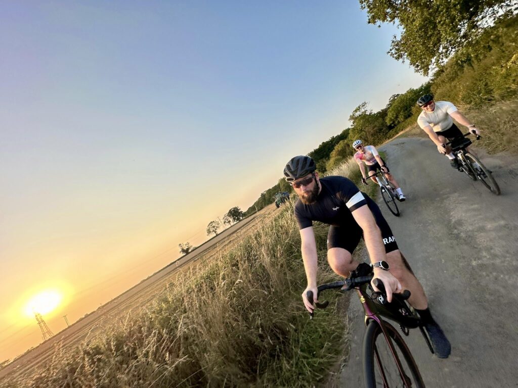 Group of cyclists on a road at sunset