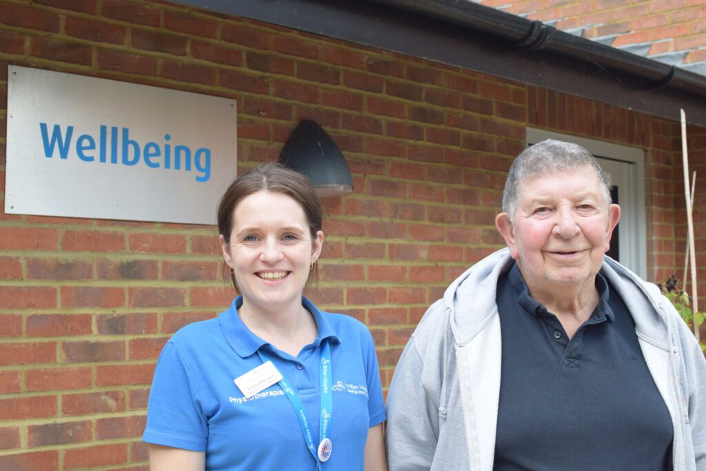 Man standing with a lady by a 'wellbeing' sign