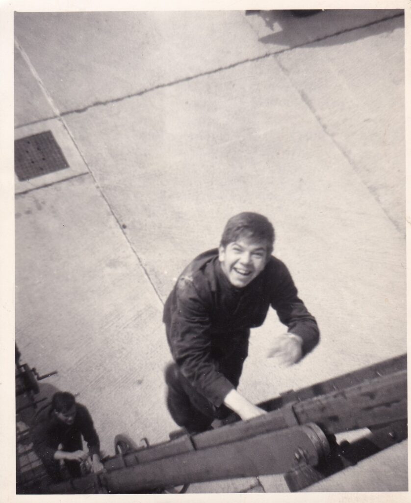 Black and white photos of young man climbing ladder