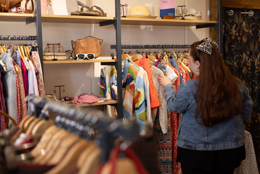 Customer browsing shop clothes rails
