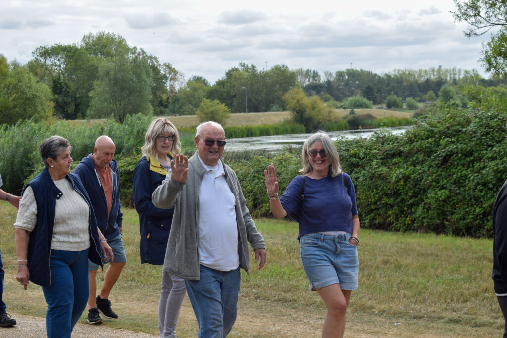 Group of people walking outside and waving at camera
