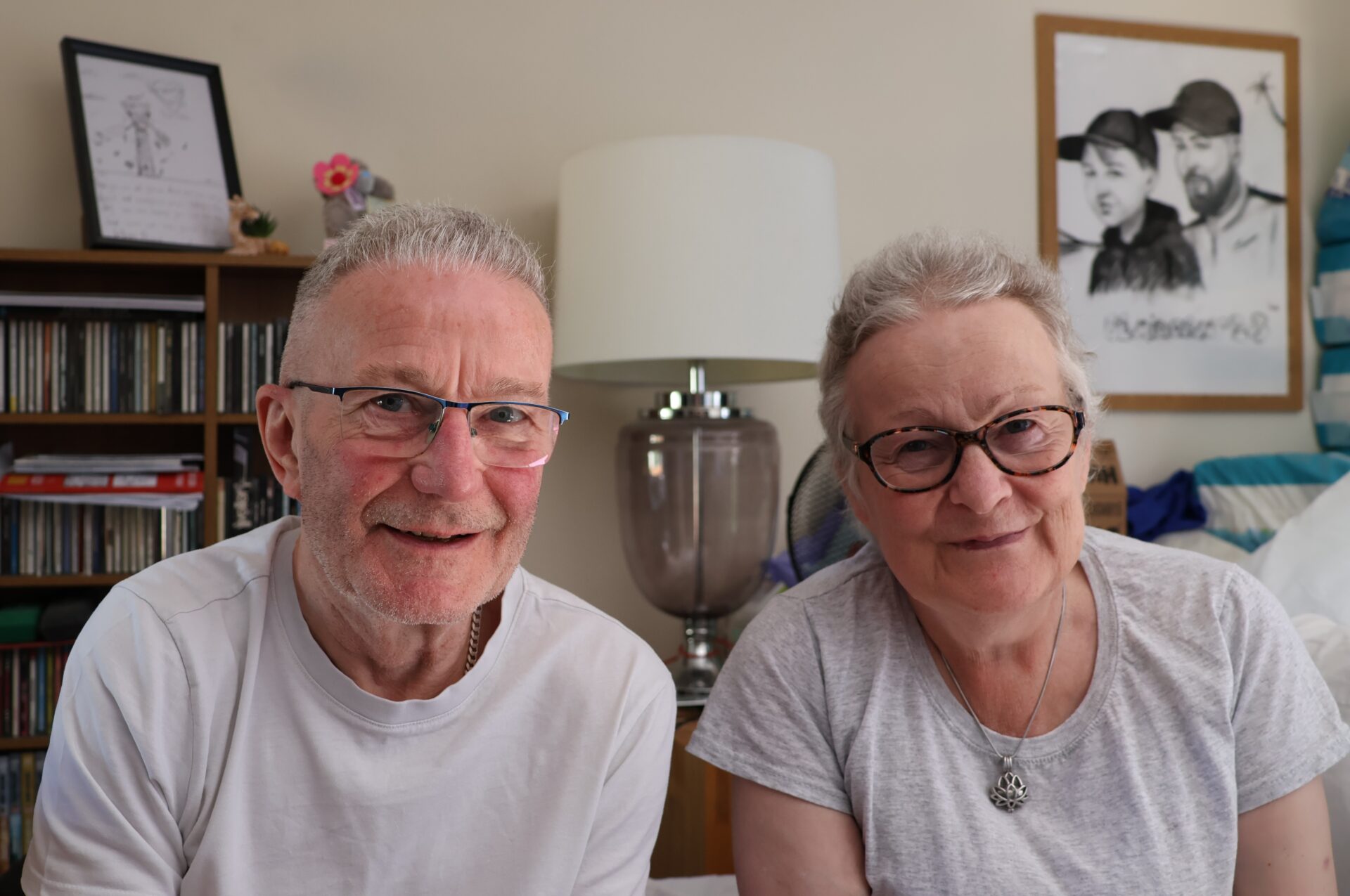 Man and woman sitting in a living room smiling at camera