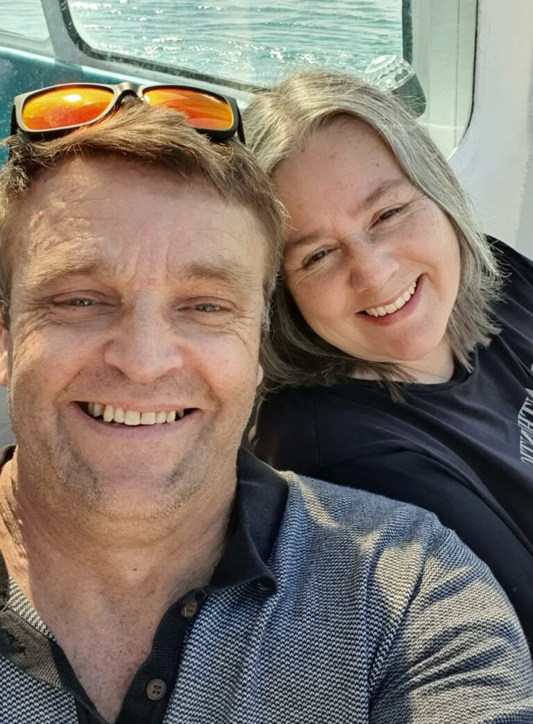 Man and woman in a boat smiling at camera