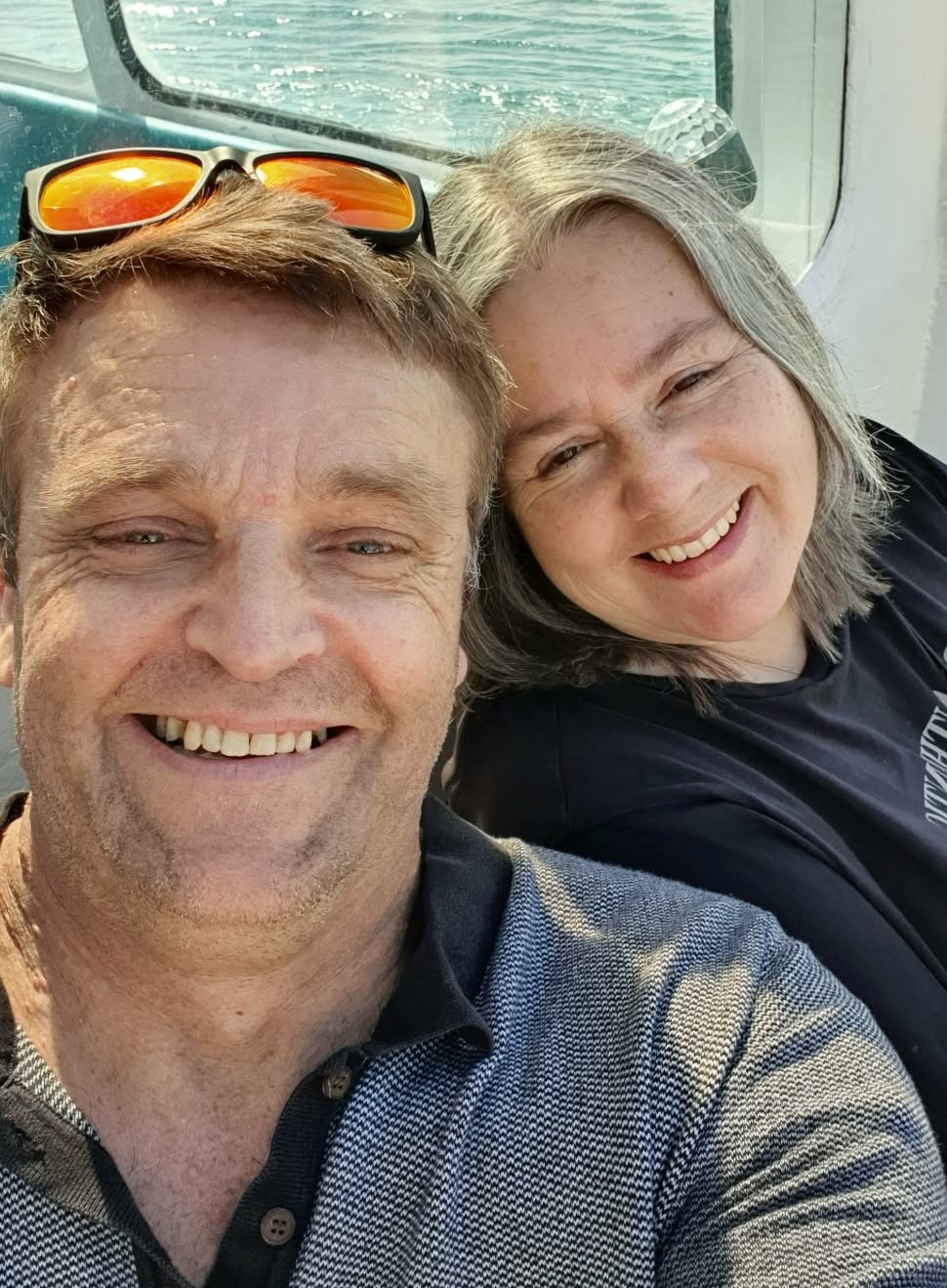 Man and woman in a boat smiling at camera